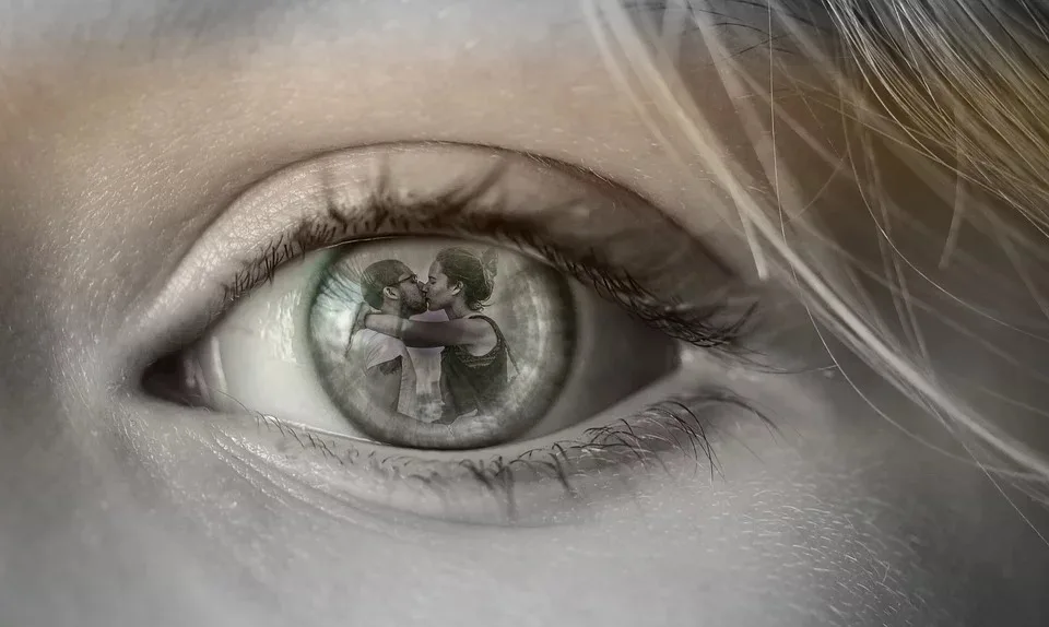 un ojo en el que se refleja una pareja besándose.