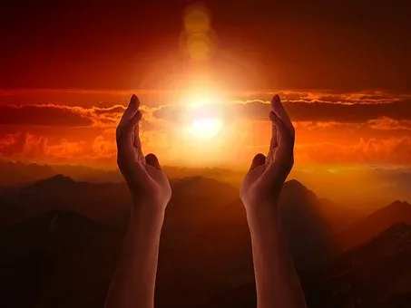 Unas manos así el cielo con el sol entre ellos.