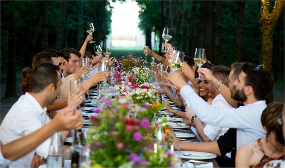 Grupo de invitados a una comida brindando.