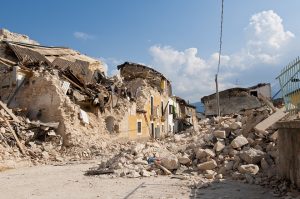 Imagen de una calle devastada por los efectos de un sismo, en la que solo se ven escombros de casa.