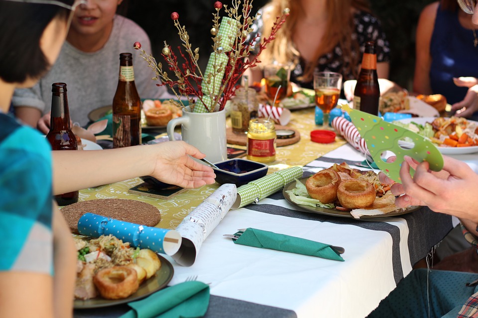 Personas conviviendo alrededor de una mesa con alimentos.