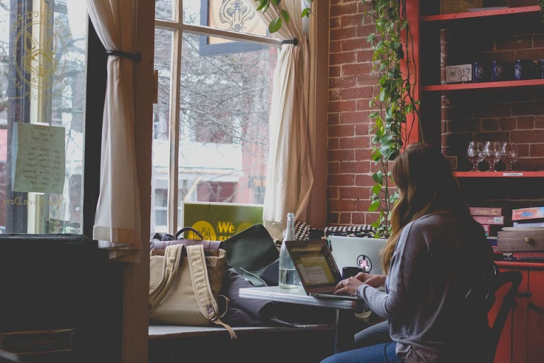 mujer trabajando en su escritorio en casa ante una ventana